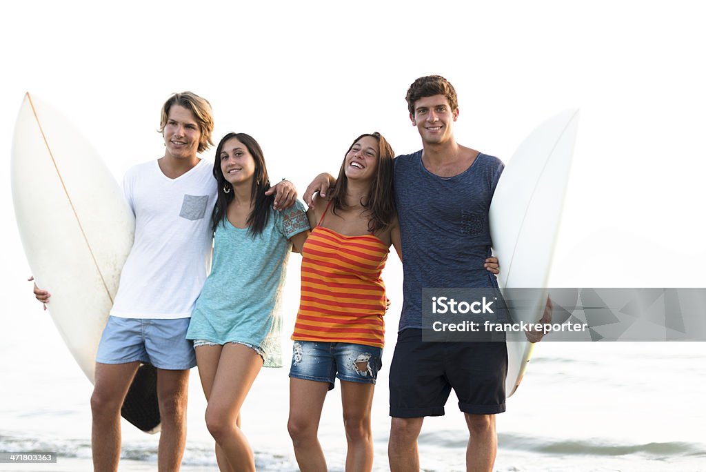 Gruppe von Menschen umarmen bei Sonnenuntergang mit Surfbrett - Lizenzfrei Berufliche Partnerschaft Stock-Foto