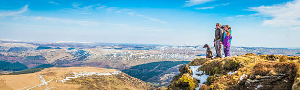 familie mutter kinder wandern auf der mountain summit mit blick auf die landschaft - child lifestyles isolated blue stock-fotos und bilder