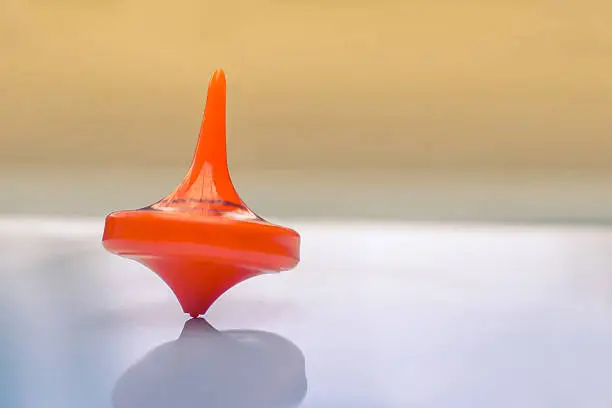 Spinning top twisting on a white table.