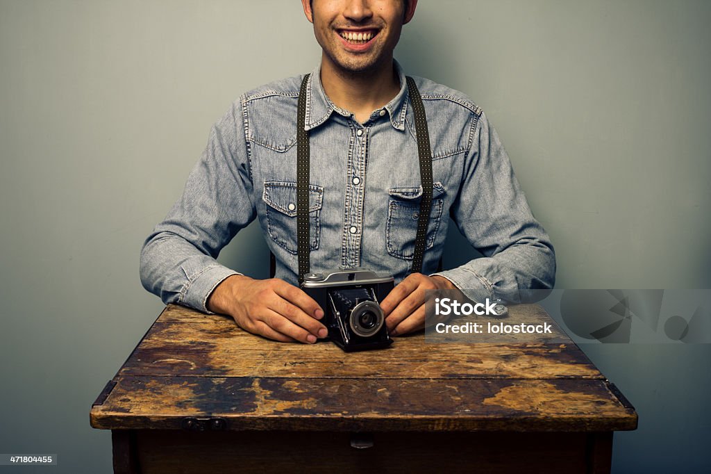 Trendy man with vintage camera at old desk Adults Only Stock Photo