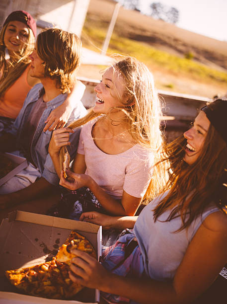 istock Friends laughing and enjoying pizza on a summer day 471805062