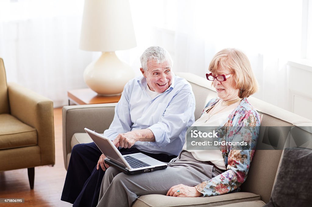 Elderly couple at home using laptop 70-79 Years Stock Photo