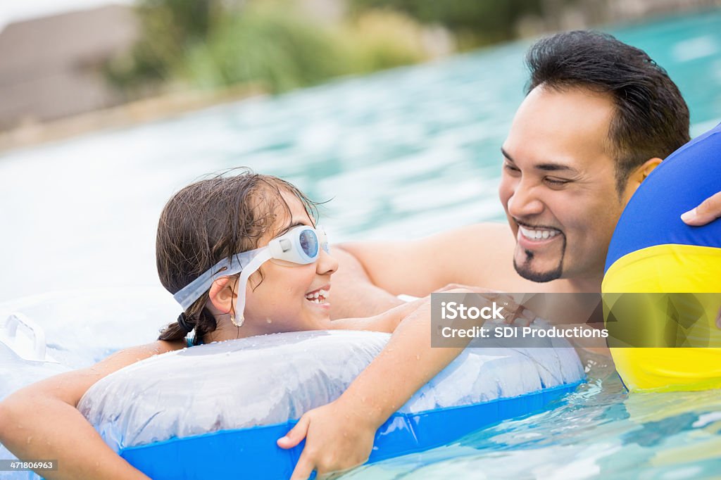 Hispânica pai nadar na piscina com a filha - Foto de stock de Família royalty-free