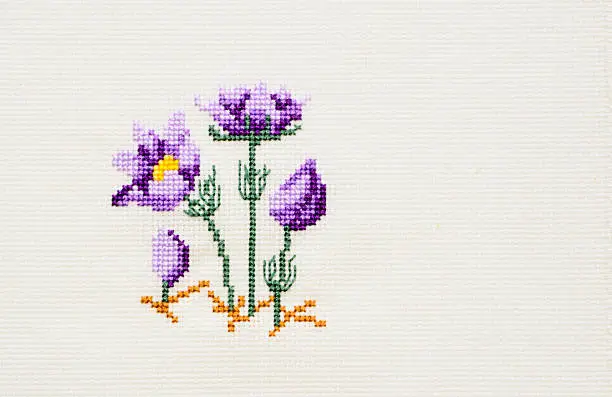 Bright colored cross-stitch wildflowers on white canvas