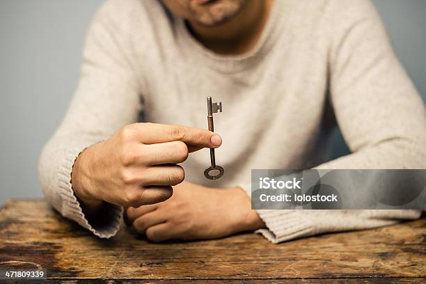 Homem Na Mesa Segurando Uma Chave - Fotografias de stock e mais imagens de Fechadura - Fechadura, Abrir, Arca de Tesouro