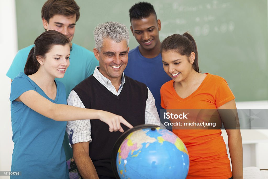 Uczniów szkół średnich i nauczyciel, patrząc na całym świecie - Zbiór zdjęć royalty-free (Globus - Wyposażenie do nawigacji)