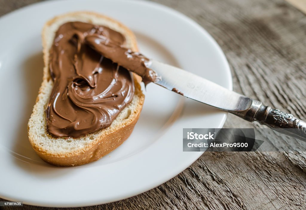 Fetta di pane con crema di cioccolato - Foto stock royalty-free di Crema di cioccolato