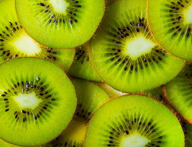 Background of sliced kiwi layered background made with a heap of sliced kiwis kiwi fruit stock pictures, royalty-free photos & images