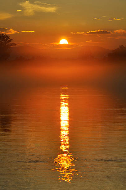 Puesta de sol sobre el río en la niebla - foto de stock