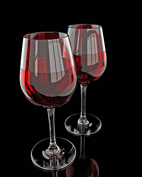 istock Two wine glasses with red wine on reflected table isolated on black. 471816874