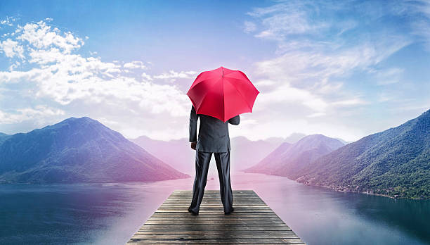 istock Man with umbrella standing on te pier 471818204