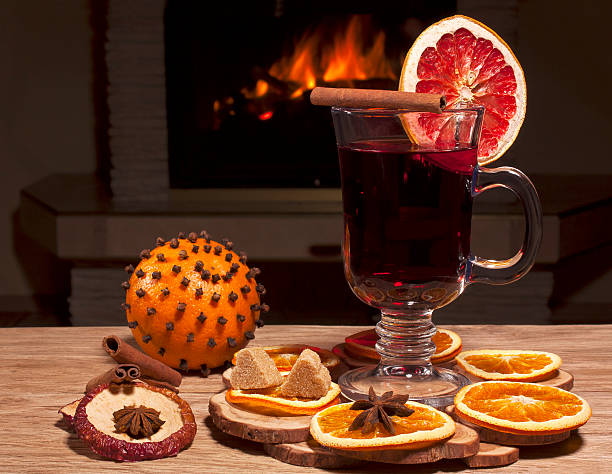 glass of mulled wine glass of mulled wine on the background of a burning fireplace scent container stock pictures, royalty-free photos & images