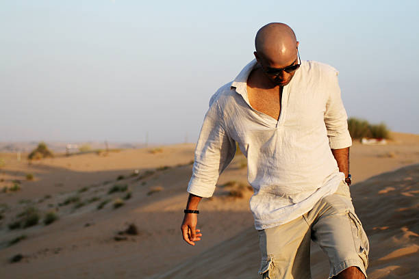 homem andando na areia no deserto - sparse sky sunlight africa - fotografias e filmes do acervo