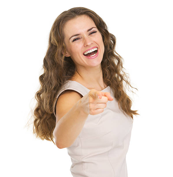 istock Smiling young woman pointing in camera 471818737