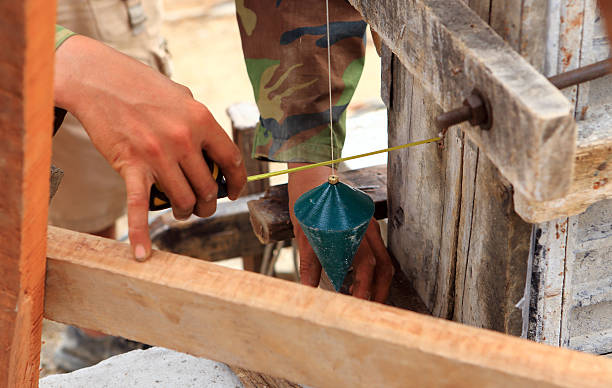 homem com uma mão-de-obra plumb bob para verificar - plumbline imagens e fotografias de stock