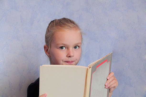 istock Girl with blond hair reading a book 471822407