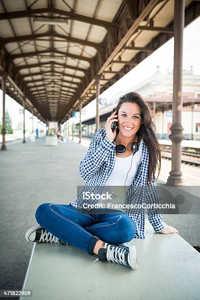 Giovane Donna Felice Con Smartphone Alla Stazione Ferroviaria - Fotografie stock e altre immagini di Abbigliamento casual