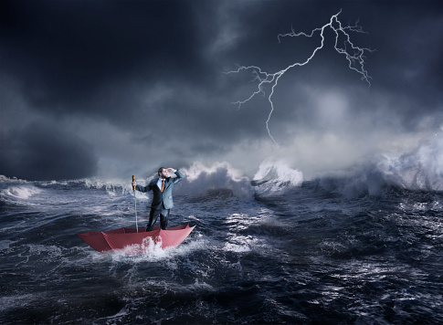 Businessman in the umbrella sails in storm in the night