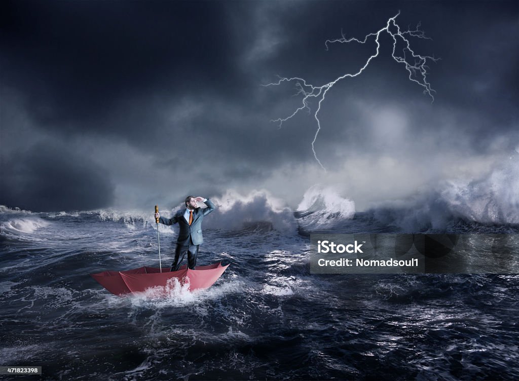 Businessman in crisis Businessman in the umbrella sails in storm in the night Rough Stock Photo