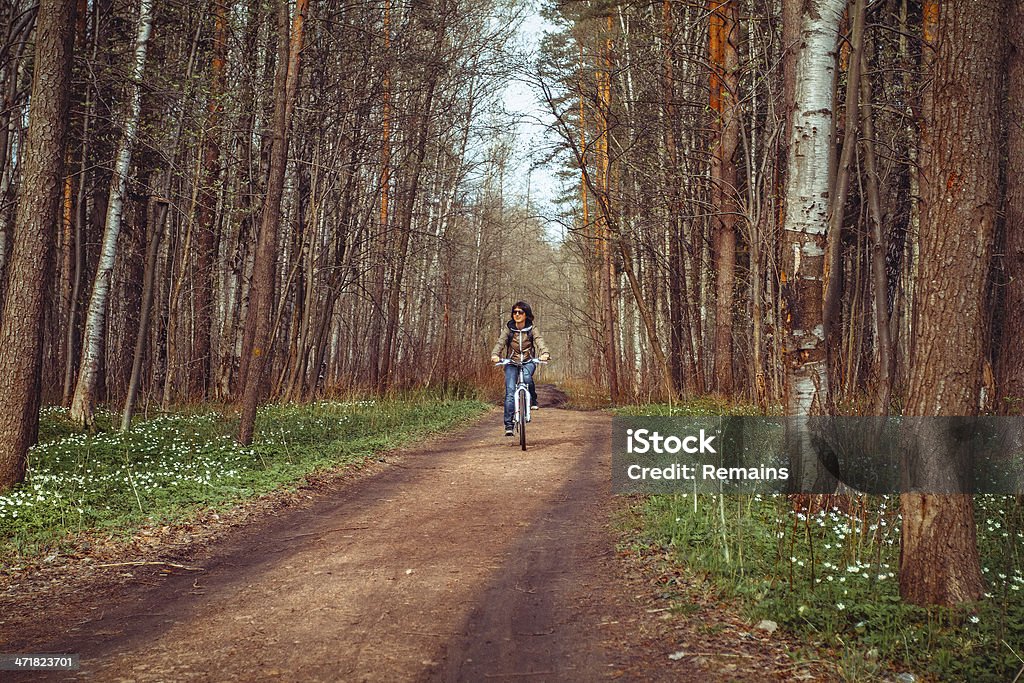 Jovem mulher com bicicleta em uma estrada - Foto de stock de Adulto royalty-free