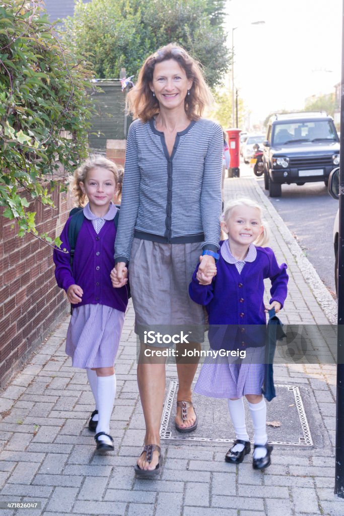 School Run Back to school. Mother and two young daughters on the school run after the summer holidays on the first day of term. Child Stock Photo