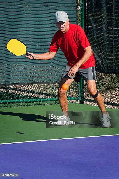 Pickleball Acciónsenior Hombre Va Volea Toma Foto de stock y más banco de imágenes de Pickleball - Pickleball, Atleta - Papel social, Pala de tenis de mesa