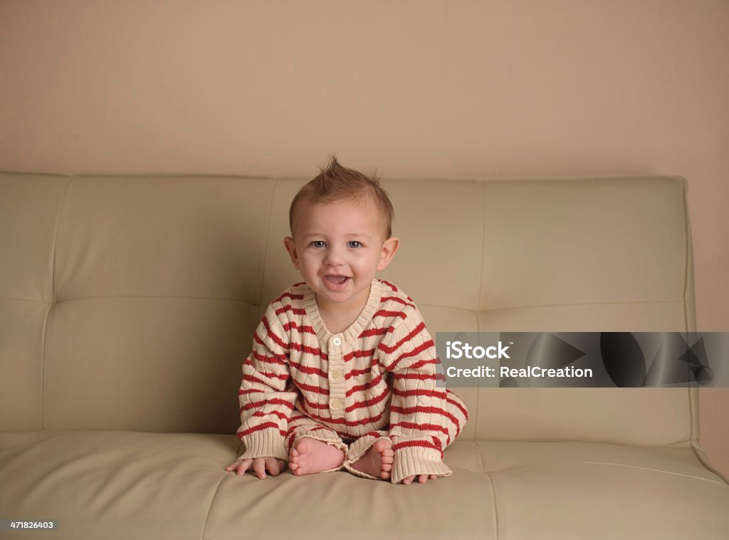 Bebê sentado no sofá usando Pijamas - Foto de stock de Bebê royalty-free