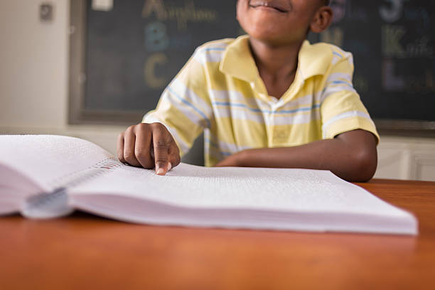 Young child learning Braille in classroom stock photo