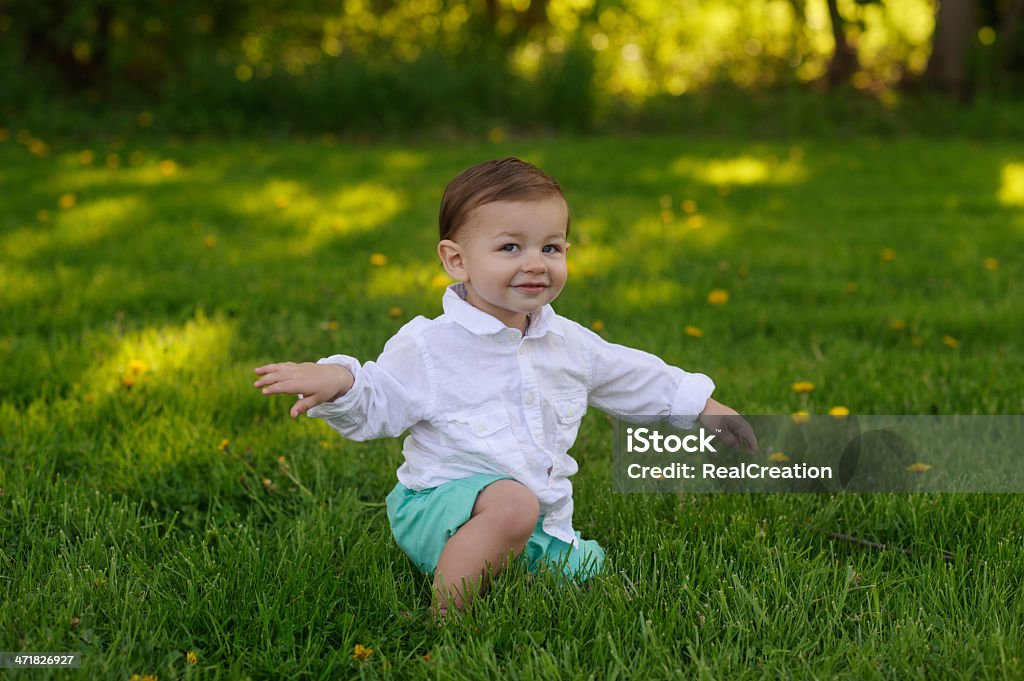 Carino bambino seduto sull'erba - Foto stock royalty-free di 12-23 mesi