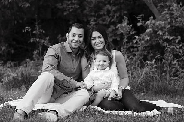 istock Young Family Sitting on Grass 471826943