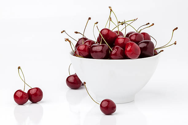 istock Cherries and bowl on white. 471827957