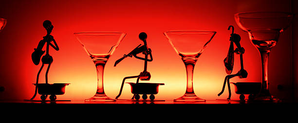 Wine glasses and statuetes in red light stock photo