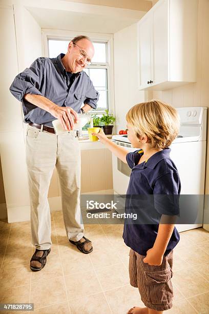 Nonno Versare Il Latte Per Il Suo Nipote - Fotografie stock e altre immagini di 4-5 anni - 4-5 anni, 70-79 anni, Adulto