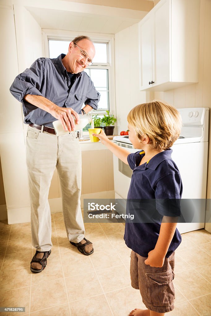 Dziadek wlewając mleko do jego Wnuk - Zbiór zdjęć royalty-free (4 - 5 lat)