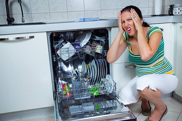 istock Woman sits near to the open dishwasher on kitchen 471830877
