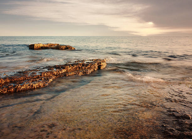 Blurred waves crashing on the rocky beach