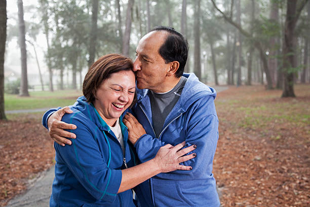 hispânico casal sênior abraçando no parque - couple mature adult action walking - fotografias e filmes do acervo