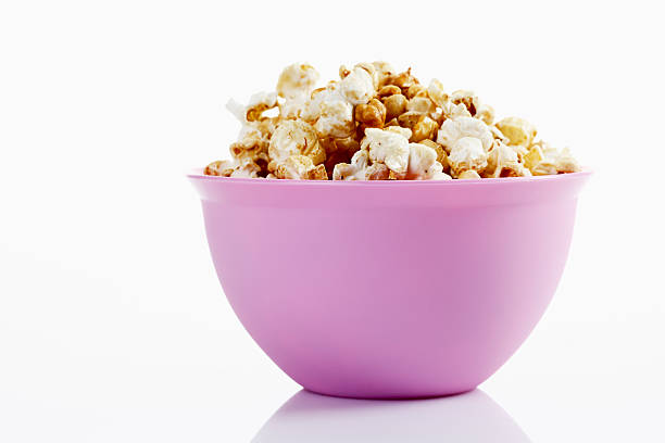 istock Popcorn in purple bowl on white background 471835996