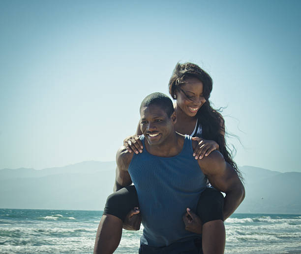 istock Young couple piggyback on the beach 471837539