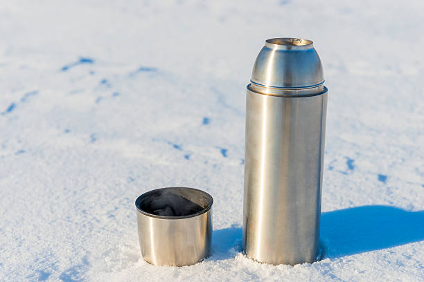 istock open thermos with boiling water in the snow 471838844