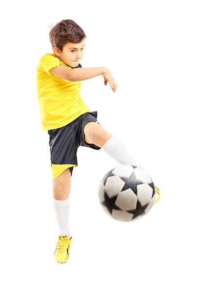 bambino in abbigliamento sportivo realizzato un pallone da calcio - little boys people indoors soccer foto e immagini stock