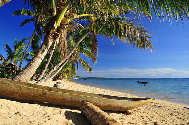 Vohilava, Nosy Boraha, Analanjirofo region, Toamasina province, Madagascar: dugout canoe under the coconut trees, tropical beach on the Indian Ocean - St Mary Island - Île Sainte Marie - photo by M.Torres