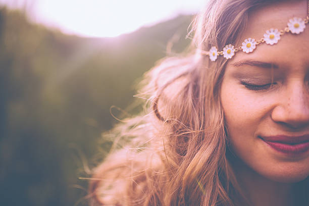 Face of a boho girl with a vintage flowered headband Closeup of a the face of a smiling boho girl wearing a vintage flowered headband bohemia stock pictures, royalty-free photos & images