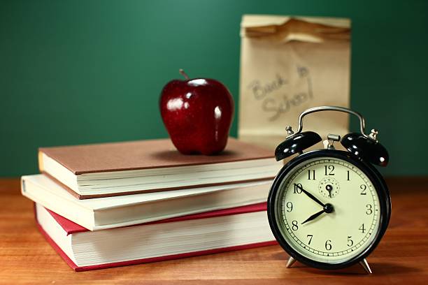 istock Sack Lunch, Apple, Books and Clock on Desk at School 471841585