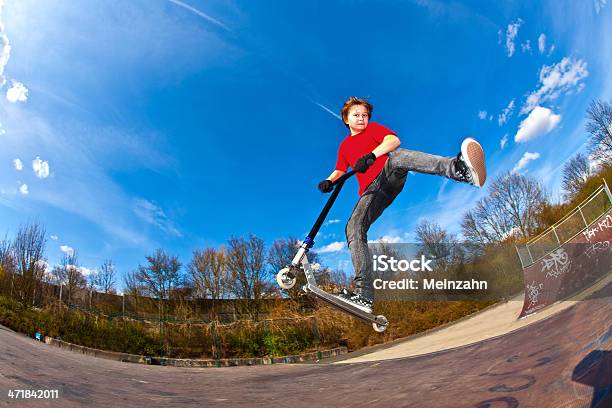 Boy Riding Scooter Is Jumping At A Skate Park Stock Photo - Download Image Now - Push Scooter, Child, Fish-Eye Lens