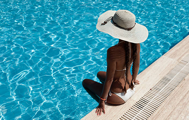 istock Woman with hat relaxing by the pool 471842507