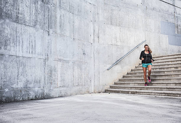 istock Woman exercising down outdoor concrete steps 471843338