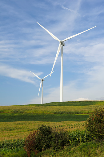 Wind turbines on scenic farmland hillsides under beautiful summer clouds in rural Pennsylvania, PA, USA.