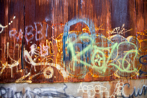 Detail and texture from corrugated metal being graffitied.