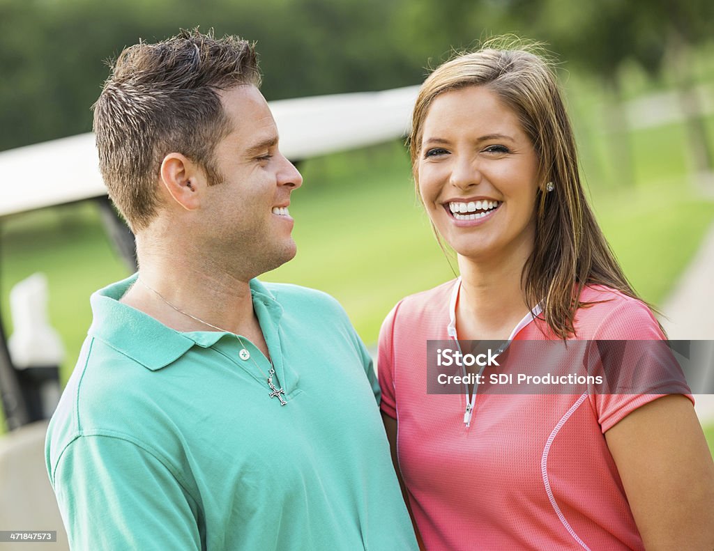 Happy couple playing golf together on course Females Stock Photo